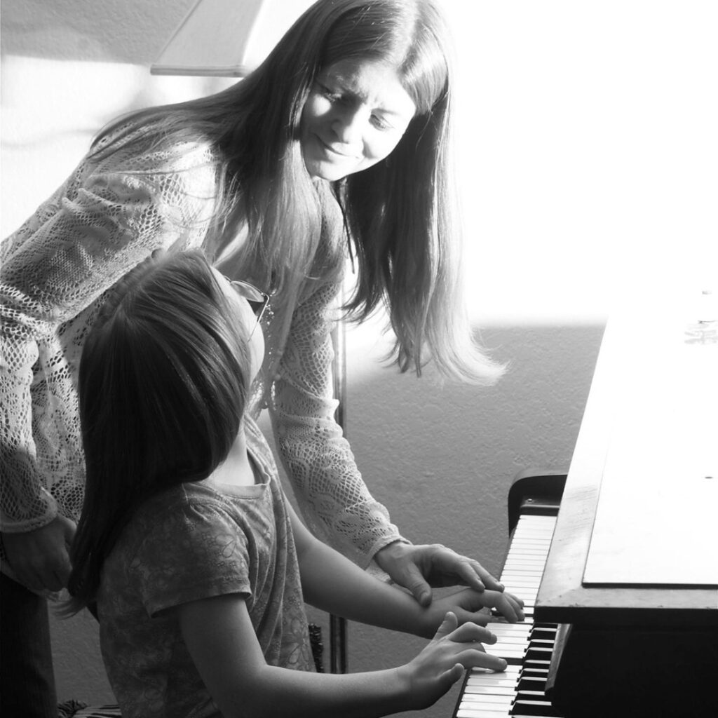 Mom and daughter playing the piano