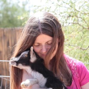Vegan mom with baby goat in her arms