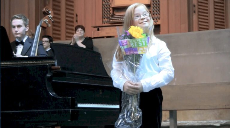 Girl with Down Syndrome performing a piano concert