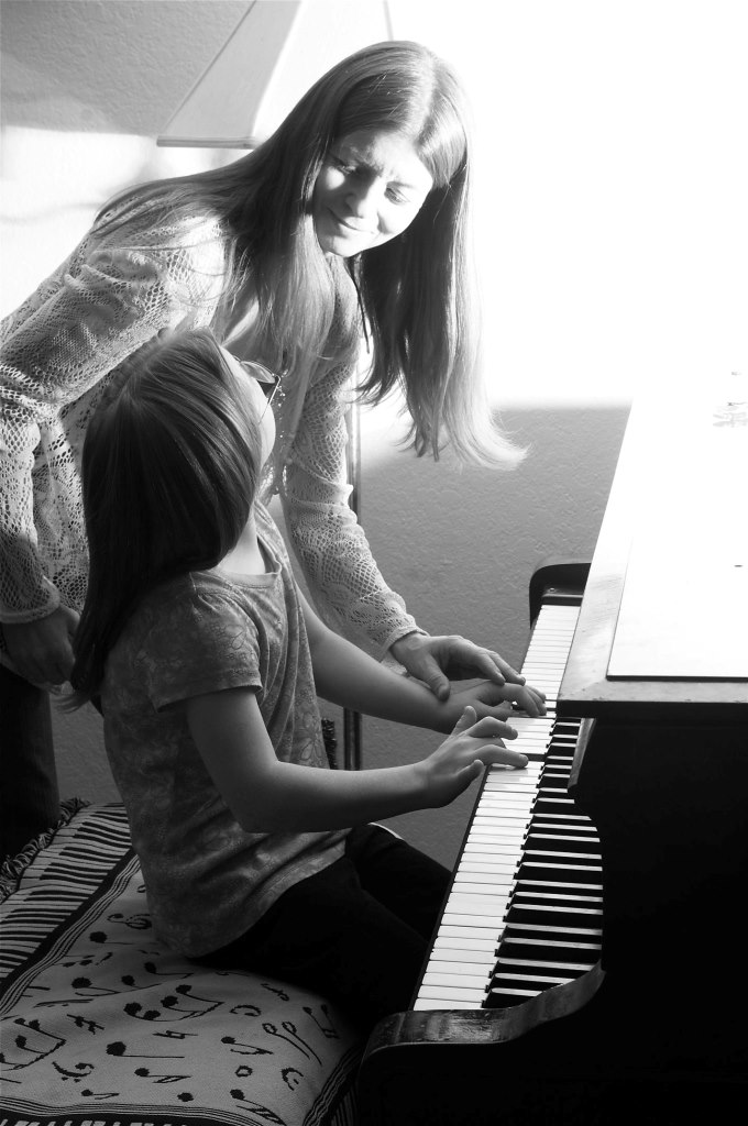 Mom and daughter playing the piano