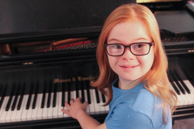 Girl with Down Syndrome playing a piano