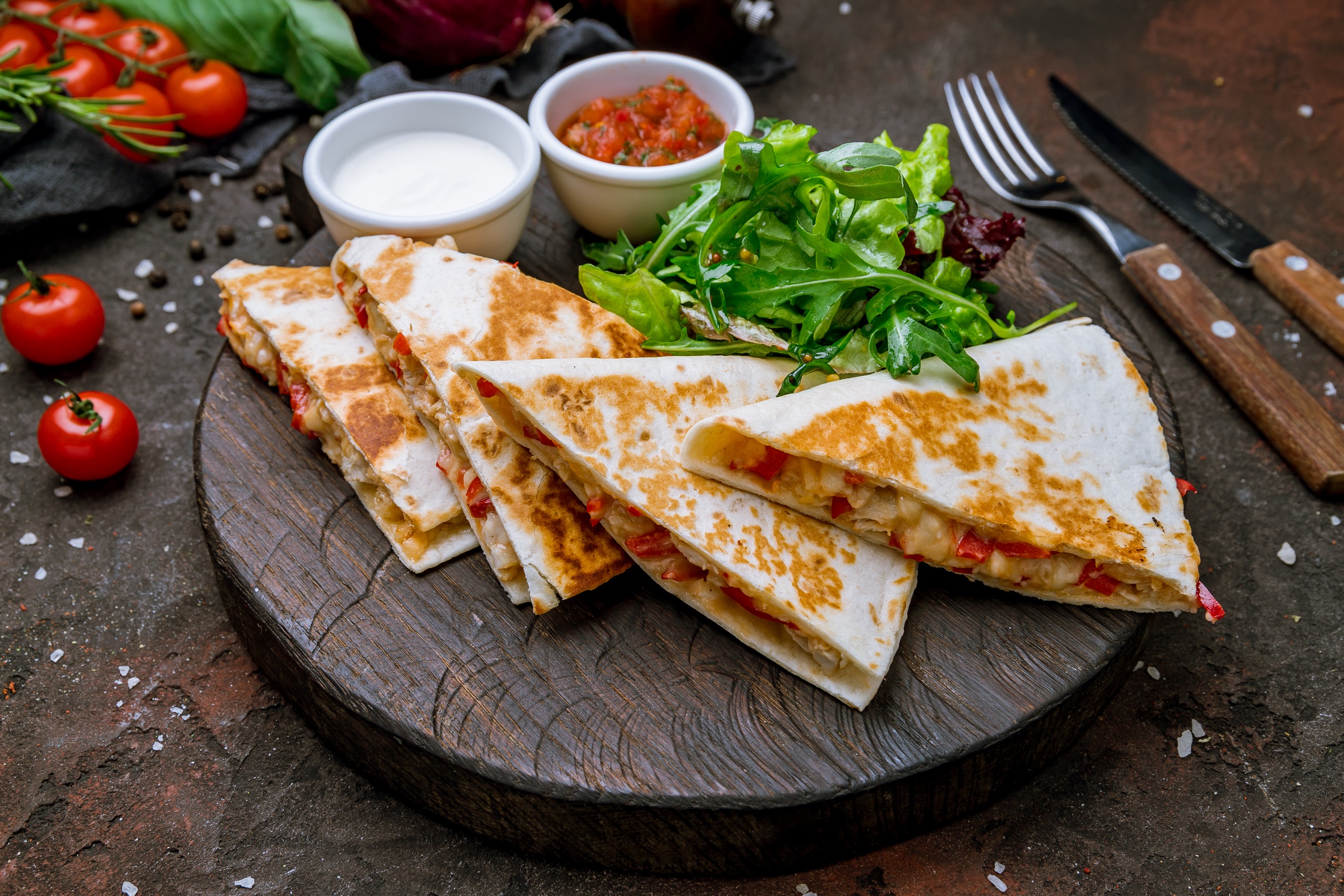 Vegan Quesadilla with chicken and sauces on dark board , on dark rustic concrete background